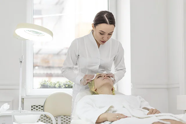 Beautician using a device for a facial treatment